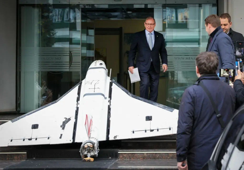 Oleg Ozerov (C), Ambassador of the Russian Federation to Chisinau, looks at a Russian-made Gerbera drone recovered by the Moldovan police on November 25, 2025, and exposed on the stairs at the entrance of the Ministry of Foreign Affairs (MAEIE) of Moldova in Chisinau, on November 26, 2025. Russia's Ambassador to Moldova, Oleg Ozerov was summoned at MAEIE in the context of several drones flying over the airspace of the Republic of Moldova. One of the drones crashed in Floresti district on November 25, 2025. (Photo by Elena COVALENCO / AFP/Eastnews)