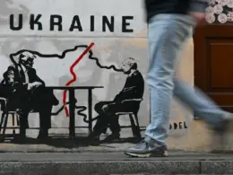 A man walks past a mural by Norwegian street artist Toddel depicting a map of Ukraine and US President Donald Trump (L) with Russia's President Vladimir Putin in Krakow on March 6, 2026, amid the Russian invasion of Ukraine. (Photo by Sergei GAPON / AFP) / Eastnews)