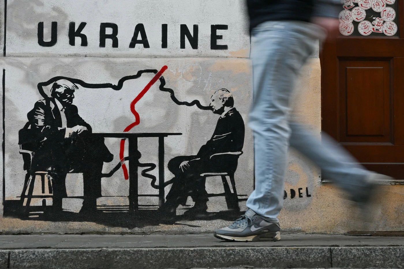 A man walks past a mural by Norwegian street artist Toddel depicting a map of Ukraine and US President Donald Trump (L) with Russia's President Vladimir Putin in Krakow on March 6, 2026, amid the Russian invasion of Ukraine. (Photo by Sergei GAPON / AFP) / Eastnews)